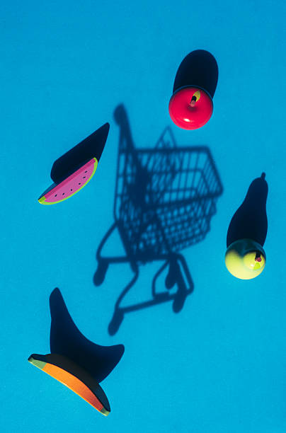 Floating shopping cart shadow with levitating fruit objects against a blue background, representing surreal grocery experiences