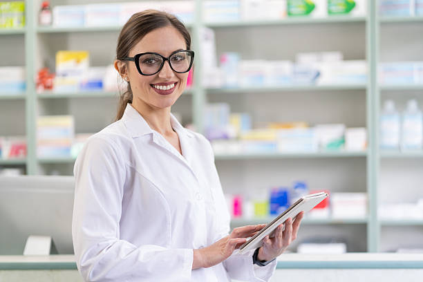 istock Female pharmacist working in pharmacy holding digital tablet 2245376280