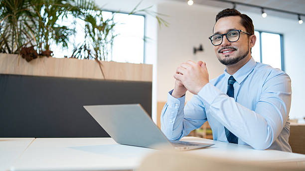 istock Smiling businessman working on a laptop at a modern office table 2245376340
