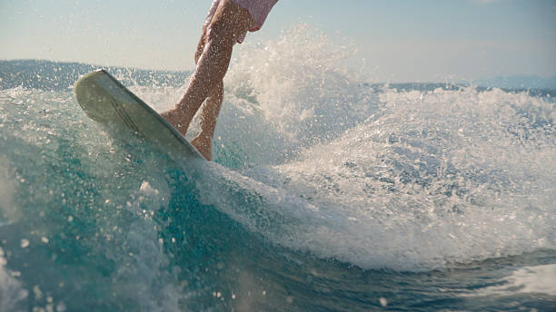 istock Low Angle View of Male Surfer Riding a Powerful Wave with Excitement 2245377242