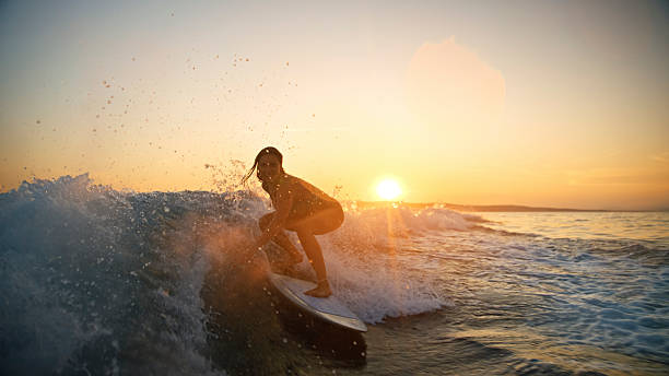istock Caucasian Woman Thrilled While Surfing Ocean Wave at Sunset 2245377350