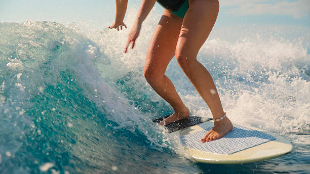 istock Woman Gliding on Surfboard Through Ocean Wave 2245377917