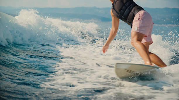 istock Young Man Wakeboarding on Sea Wave Behind Boat 2245377959