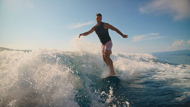 istock Caucasian Male Riding Wake Behind Boat on Clear Day 2245378010