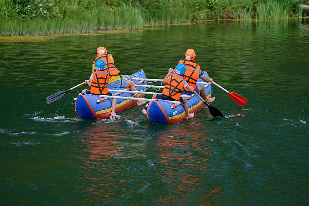 Russia, Republic of Bashkortostan, Kugarchinsky District, Bikbulatovo Village - August 5, 2023. Rear view. A family of four rowing an \