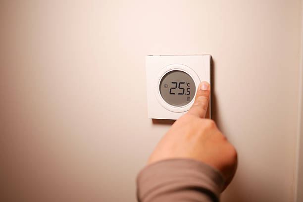 istock Adjusting the thermostat for optimal indoor temperature 2245379990