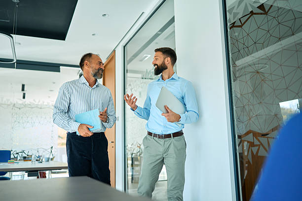 istock Businessmen colleagues discussing ideas walking through modern office 2245383243