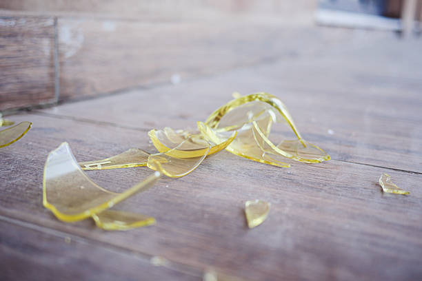 istock Broken yellow glass pieces scattered on wooden floor 2245387329