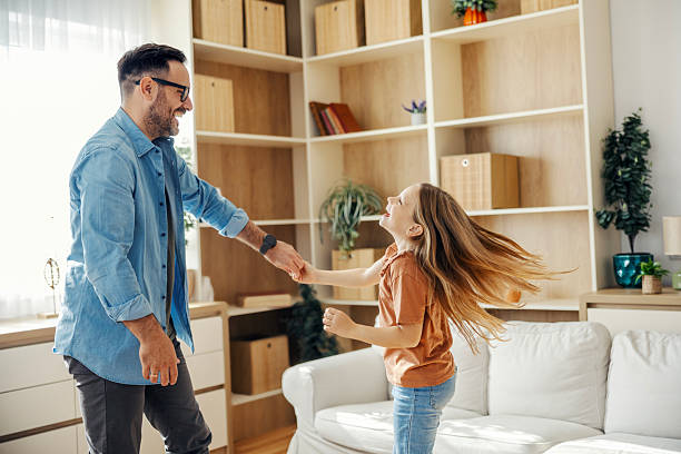 istock Father and daughter dancing in living room 2245391209
