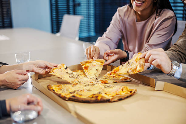 istock Coworkers sharing pizza during office lunch break 2245391680