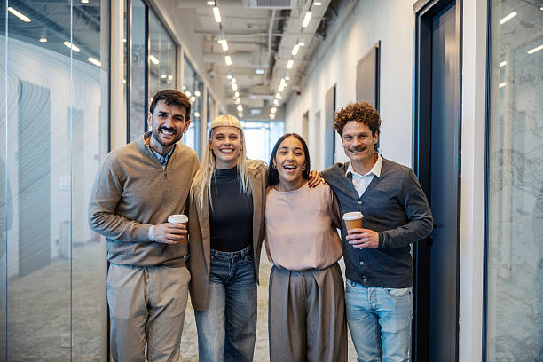 istock Diverse business team smiling at office hallway coffee break 2245391736