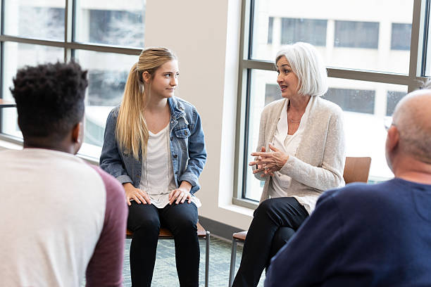 istock Supportive therapy group session in a bright, modern room with diverse participants. 2245393352