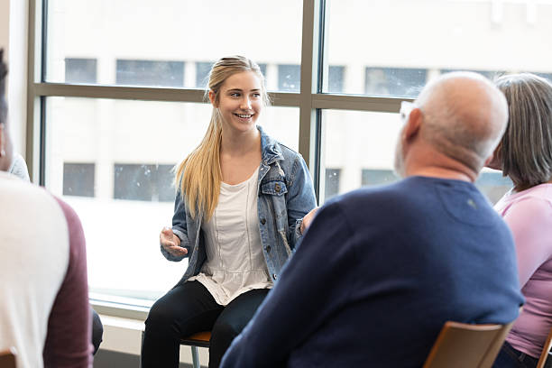 Diverse group in discussion, focusing on shared experiences and support within a meeting.