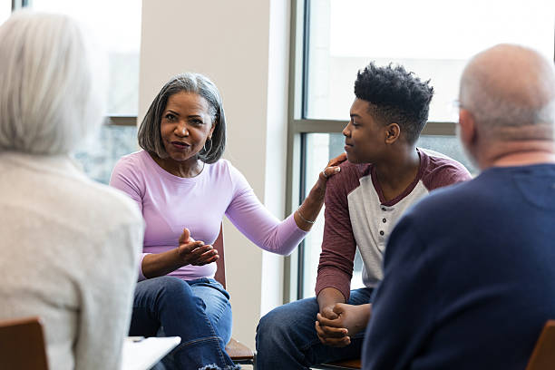 istock Experienced woman offering support and guidance to a young person during a group session. 2245393386