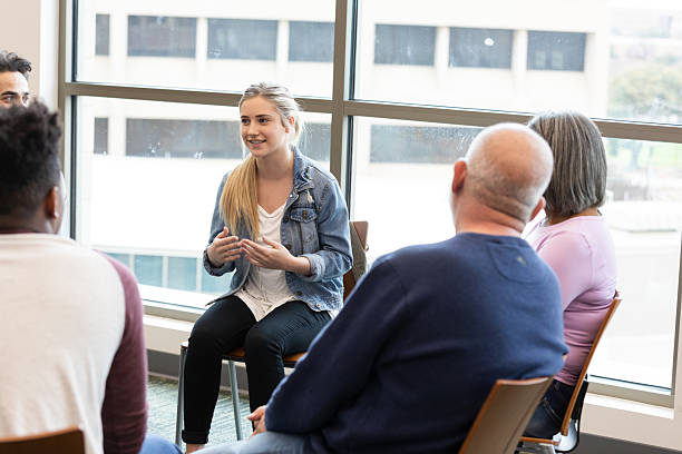 istock Young woman actively engages in a group discussion, sharing her thoughts openly. 2245393399
