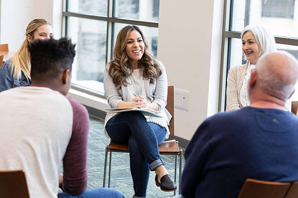 istock Diverse group engaged in supportive discussion during a counseling session indoors. 2245393415