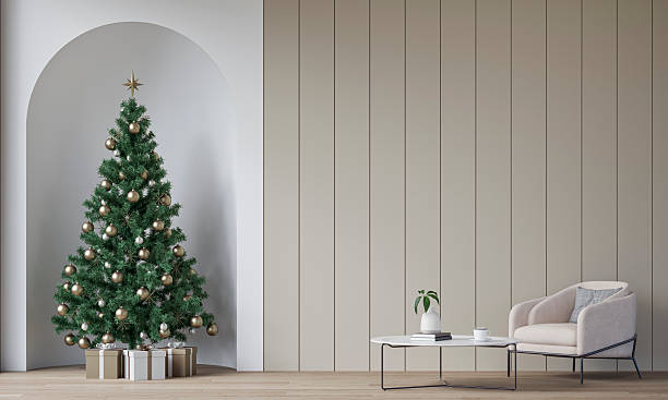 istock Modern minimalist interior decorated for Christmas, with a  cozy armchair and side table in front of a beige shiplap wall background, a Christmas tree with presents in a wall niche, near a window 2245396878