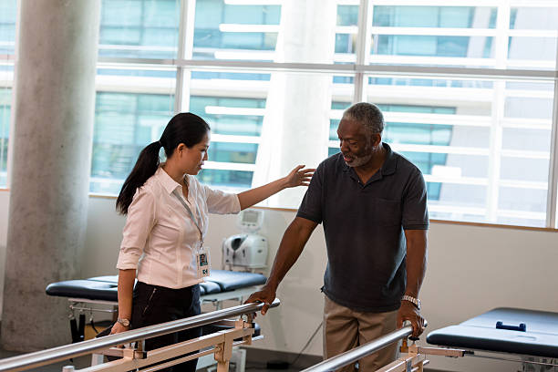 istock Physical therapist assisting an elderly man with a walker in a clinic 2245398354