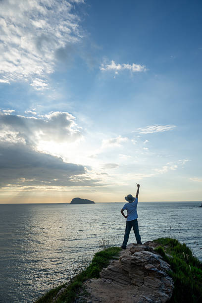 istock The successful person standing on the rock 2245399830