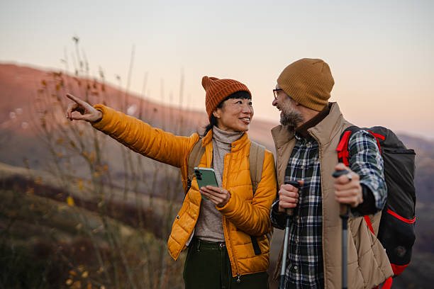 istock Couple hiking together pointing directions using smart phone navigation 2245400676