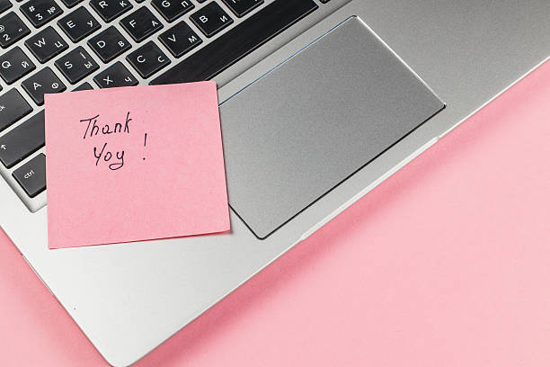 istock Thank you note on a laptop beside a silver touchpad 2245401427