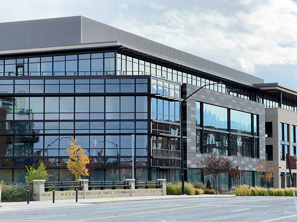 istock Modern office building glass facade reflecting cloudy sky 2245402336