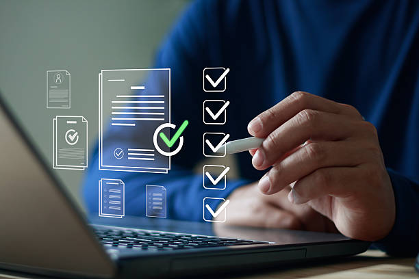 istock Close up of hand using stylus pen on laptop with digital checklist and document icons, symbolizing task management, online form approval, productivity, business planning and workflow organization. 2245403018