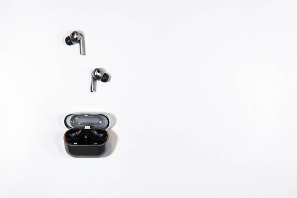 istock Stylish wireless earbuds on a clean surface with charging case nearby ready for use 2245404715