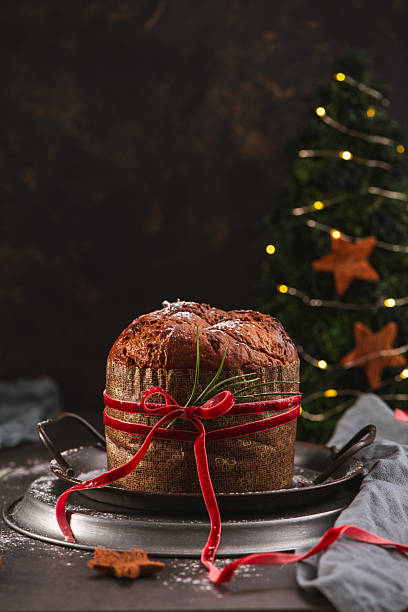 istock Panettone on Rustic Tray with Decorated Christmas Tree 2245413362