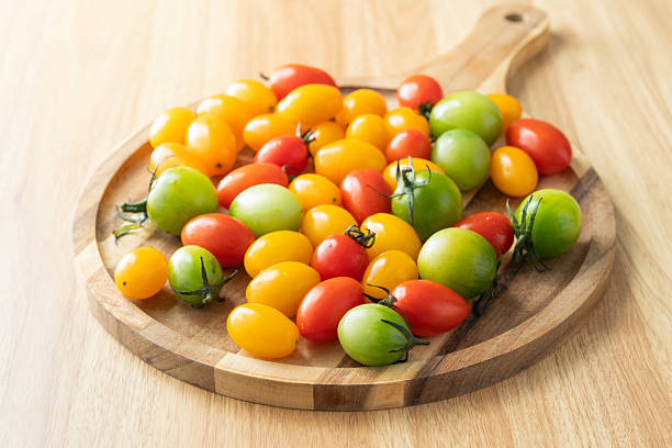 Sunlight spills over the Japanese-style floor, where a wooden board is covered with fresh yellow, red, and green cherry tomatoes gleaming like jewels.