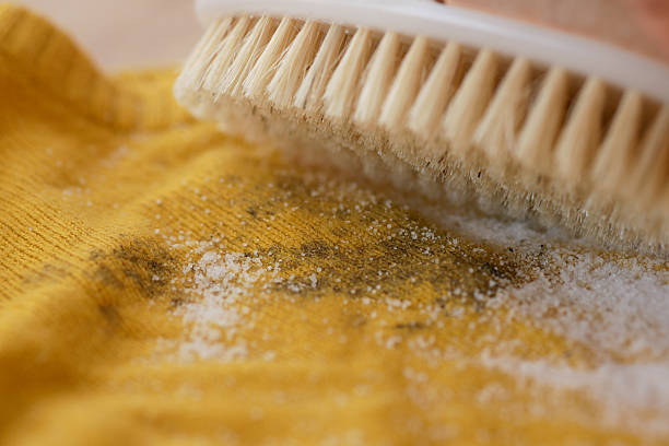 Cleaning a yellow fabric with a brush and baking soda