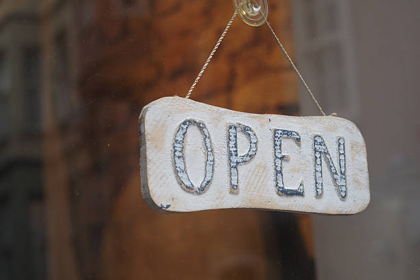 istock Wooden open sign displayed in storefront window 2245416842