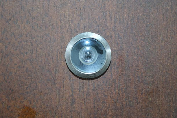istock Door Peephole on Wooden Surface 2245421782