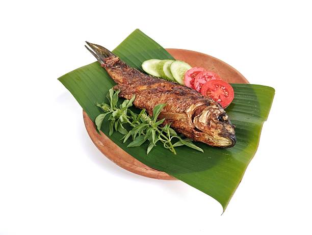 istock Fried fish with vegetable on wooden plate isolated on white background 2245422308