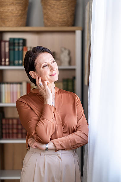 Senior woman relaxing at home looking out window