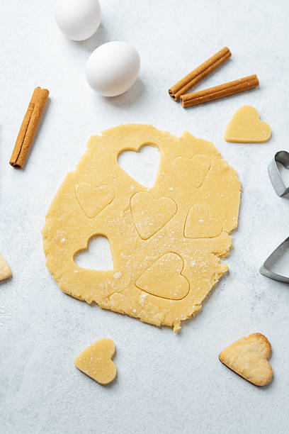 istock Heart shaped cookie dough cutting with cinnamon and eggs for baking, valentines or romantic concept 2245423572