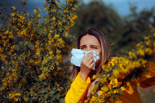 istock Woman Suffering from Allergies Wiping her Nose 2245426317