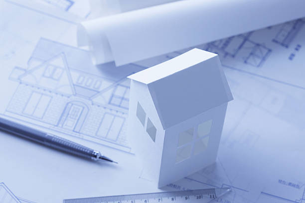 istock Paper miniature house model and blueprints 2245428222