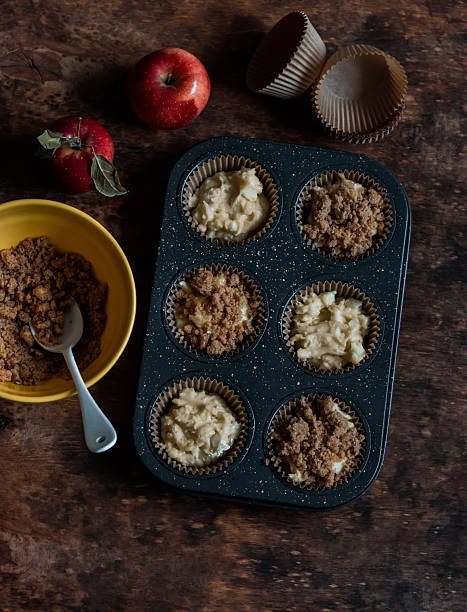 istock Making muffins with apples and cinnamon crumble on a wooden table, top view 2245428850