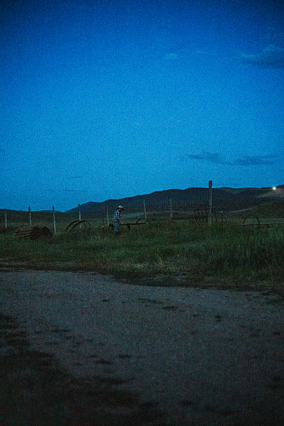 A rancher collects tools and materials in a quiet field before sunrise while preparing to install a new fence on his family ranch in Western Wyoming.