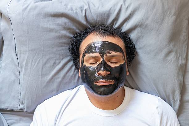 istock man with a face mask lying on his bed 2245429661