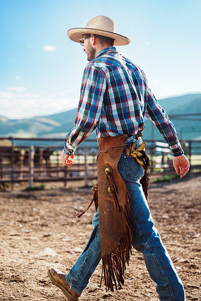 istock Rancher Wearing Leather Chaps Walking Through Corral 2245429710