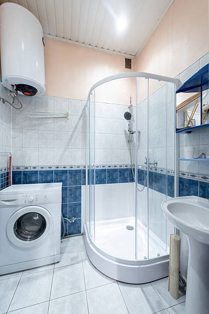 istock Modern Bathroom Interior with Shower Cabin Washing Machine and Water Heater 2245432178