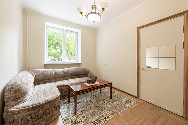 istock Small Home Living Room with Beige Wall Decor and Cozy L-Shaped Sofa 2245432193