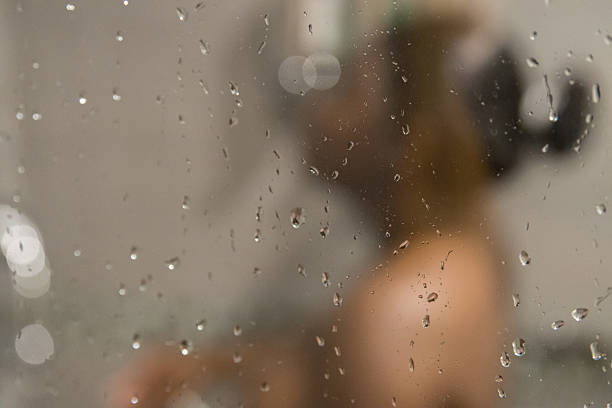 istock A woman takes a bath through a wet window 2245432992