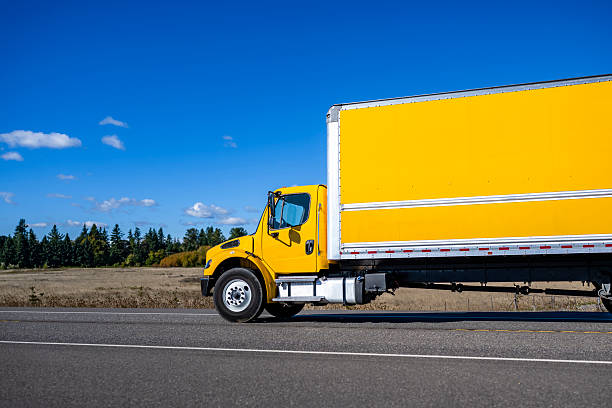 Yellow truck on a road in a sunny summer day