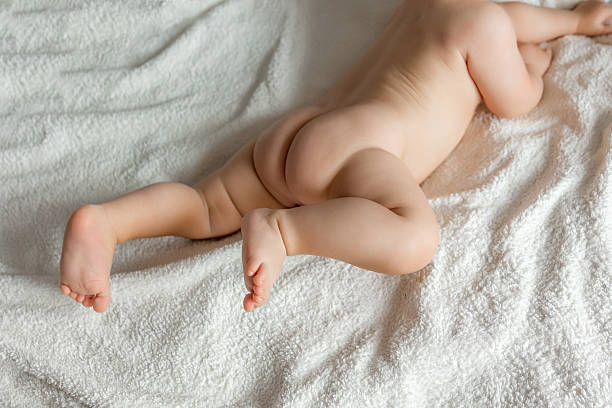 istock Baby is lying on a white sheets on tummy. 2245441466