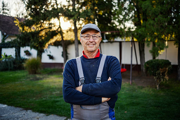 istock Senior man smiling wearing work overalls in backyard 2245442356