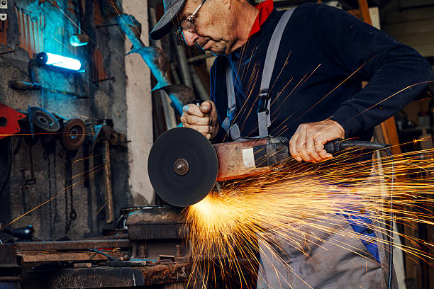 istock Experienced worker grinding metal in workshop creating sparks 2245442427