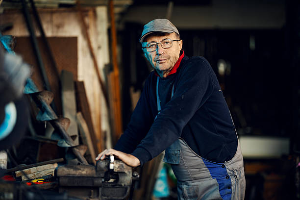istock Senior craftsman standing in workshop with vise 2245442442